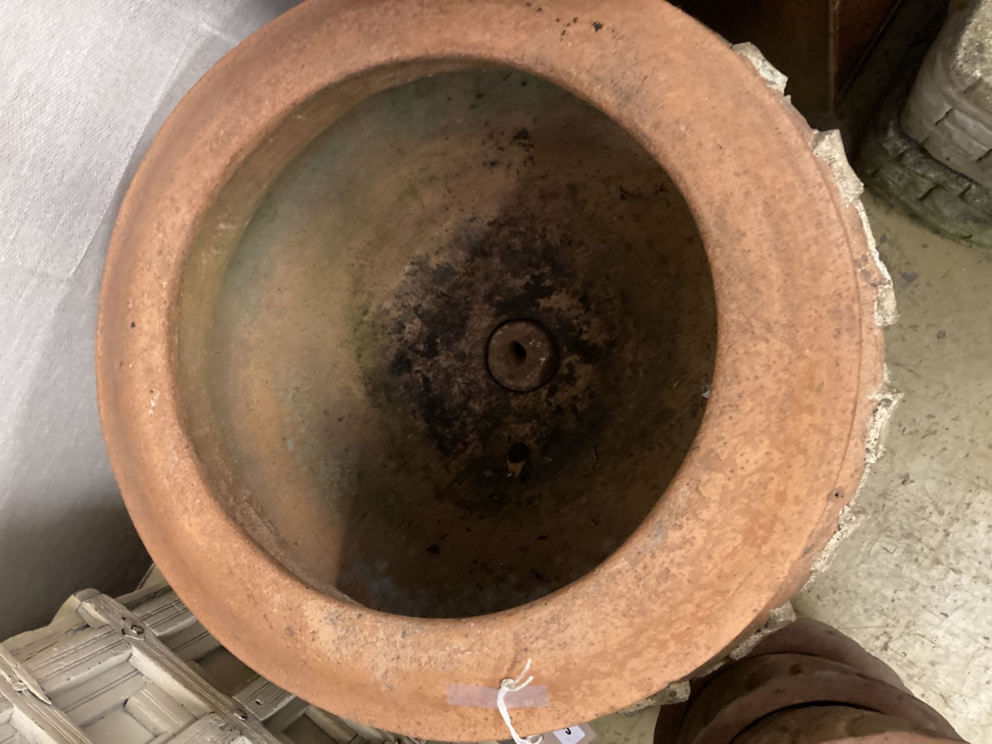 A circular terracotta garden planter on stand, diameter 56cm, height 50cm together with three smaller terracotta garden planters